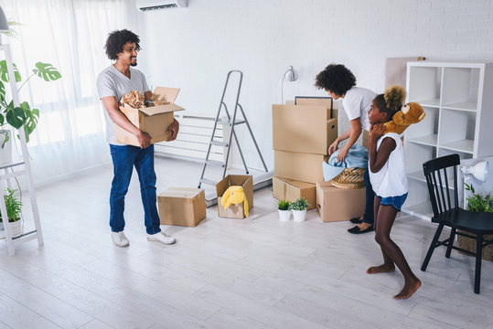 Young African-american Family Unpacking and Cleaning. Move into New Home. - Powered by Adobe