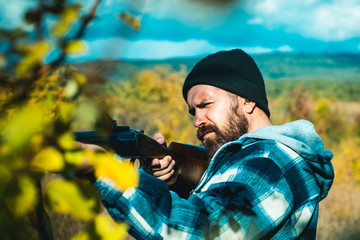 Man holding shotgun. Hunter with a shotgun in a traditional shooting clothing.