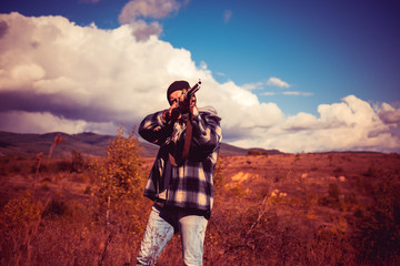 Hunter with shotgun gun on hunt. Autumn hunting season. Hunter in the fall hunting season.