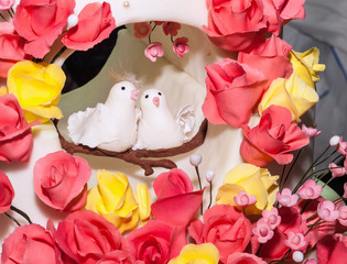 Wedding cake with figures of white doves and beautiful flowers from a pastry mastic