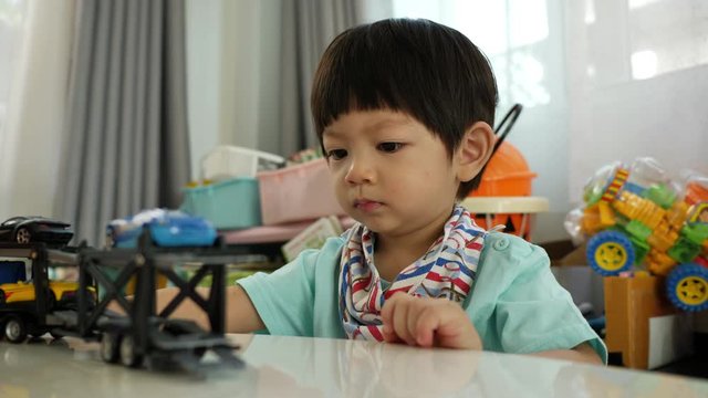 cute boy playing toy in home