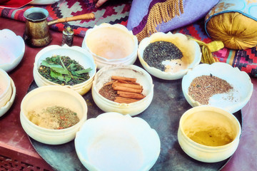Spices in half-empty bowls for sale on the market. Trade of spices at the Bazaar. A Muslim spice merchant's shop.