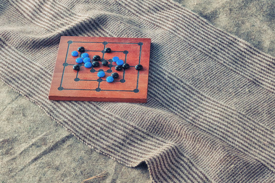 Board for the game of the mill with the placed chips. Board game with a placed position on the carpet, close-up.