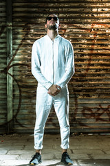 portrait of young dj in white clothes against textured background