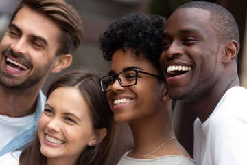 Fototapeta premium Smiling multiracial millennial friends posing for picture together