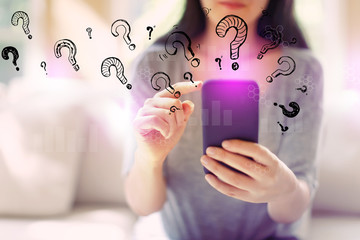 Question marks with woman using her smartphone in a living room