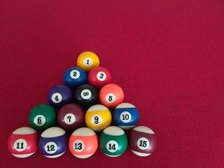 bolas de billar acomodadas sobre paño rojo