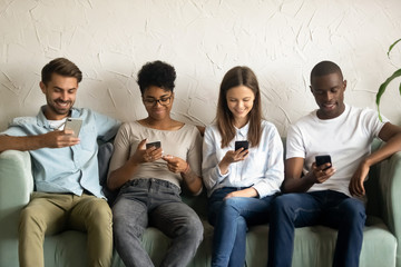Multiracial young people using smartphones waiting in queue