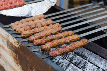 Cooking adana kebabs on a grill in restaurant 