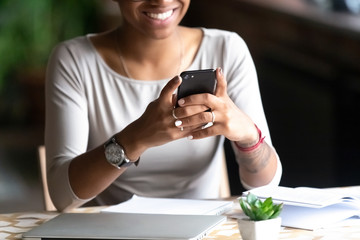 Smiling biracial woman hold cellphone chatting online