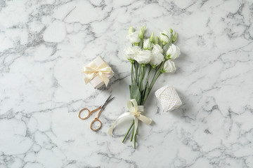 Flat lay composition with scissors and flowers on white marble background