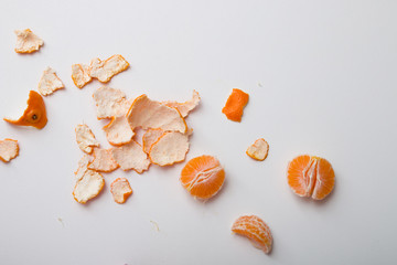 slices of tangerine and peel lie on a white table top view copy space