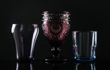 Set of different colorful empty glasses on black background