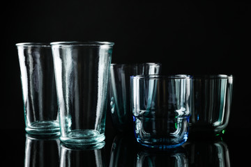 Set of different colorful empty glasses on black background