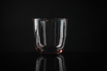 Elegant empty colorful whiskey glass on black background