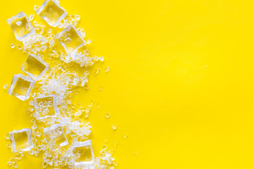 Frozen water in ice cubes on yellow bar table top view mockup