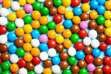 Fototapeta na wymiar Many colorful delicious candies as background, top view