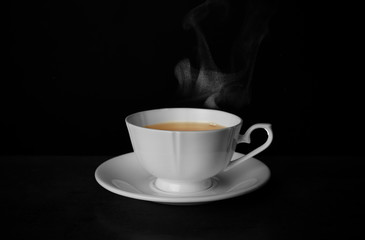 Ceramic cup of hot fresh tea on table against black background, space for text