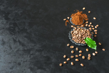 Coffee beans and ground powder on black background. Top view with copy space