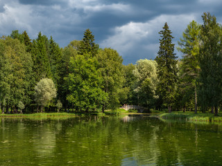 Before the rain. Summer sunny landscape with a lake in the old Park