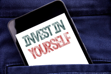 Handwriting Announcement text showing Invest In Yourself. Business concept for Self Motivation Written phone mobile phone, cellphone placed in man front jeans pocket.