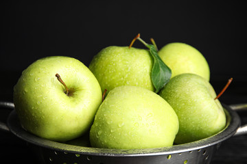 Colander of fresh ripe green apples on black background, closeup view