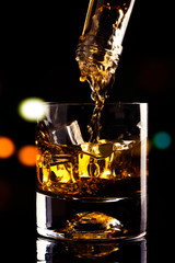 glass of whiskey and ice cube