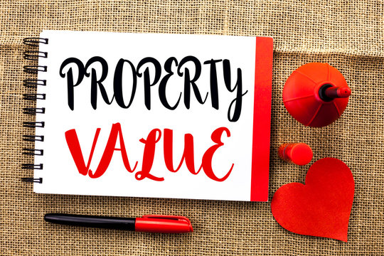 Handwriting text writing Property Value. Concept meaning Estimate of Worth Real Estate Residential Valuation written Notebooke Book the jute background Pen and Heart next to it.