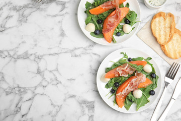 Flat lay composition of fresh melon with prosciutto on marble table. Space for text