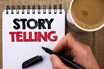 Text sign showing Story Telling. Conceptual photo Tell or write short Stories Share Personal Experiences written by Man Holding Marker Notebook Book the jute background Coffee Cup.