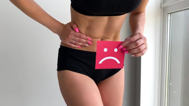 Woman Health. Female Body Holding Sad Smile Card Near Stomach.