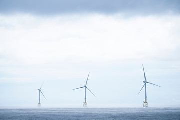 Wind turbines at electric power farm in the North Sea in Aberdeen for renewable energy production and environment conservation