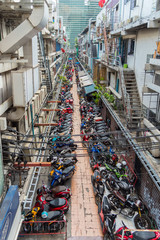 Backyard street with plenty of parked scooters and motorcycles in the Pathum Wan district of Bangkok