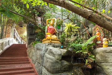 Garden with water features and gilded Tara at the steep staircase on the way up to the Wat Saket, the famous Golden Mount in Bangkok