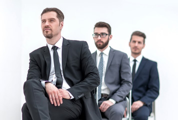 group of serious business people waiting for their turn