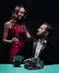 beautiful couple looking at playing cards at poker