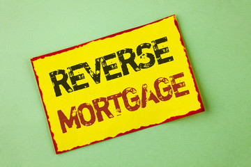 Word writing text Reverse Mortgage. Business concept for Elderly homeowner retirement option regular payment benefit written Yellow Sticky Note Paper the plain background.