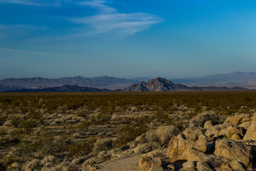 vista of the mountains and hills rising above the mojave desert