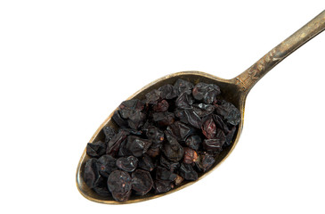 Dried barberry in an old spoon isolated on a white background. Seasoning on isolate. View from above.