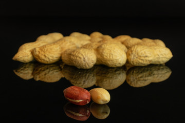 Lot of whole natural yellow peanut isolated on black glass