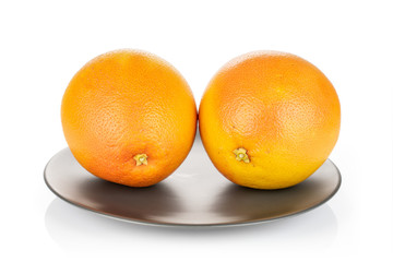 Group of two whole fresh pink grapefruit on gray ceramic plate isolated on white background