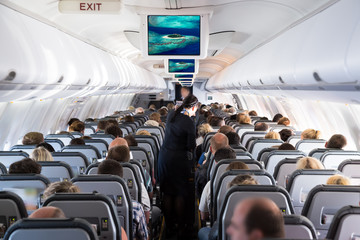 Inside view on passenger and cabin crew people on an airline airplane during flight  vacation....
