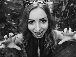I will eat you. Close-up shot woman bending towards camera with grimace and holding hands as if it...