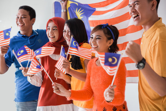malaysia people holding flag celebrating independence day together