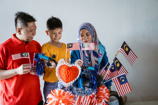 Happy Malaysian Family Decorate Bicycle With Flag For Independence Day Celebration. Malaysia Merdeka Basikal Hias