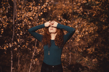 Red haired woman on autumn background. Fashion portrait of red haired woman.