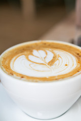 Cinnamon Latte in white mug on table at coffee shop