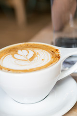 Cinnamon Latte in white mug on table at coffee shop