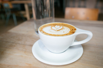 Cinnamon Latte in white mug on table at coffee shop