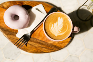 honey and lavender latte in pink mug with iced vegan donut, white background, hipster coffee shop, latte art